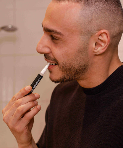 image of man using teeth whitening gel pen